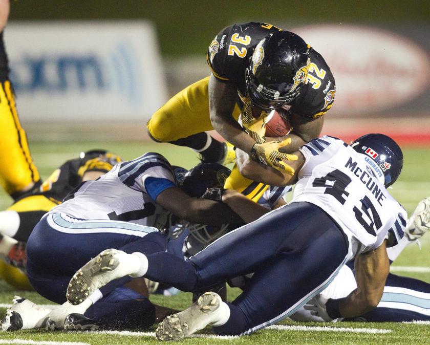 Hamilton Tiger-Cats C.J. Gable (top) dives over Toronto Argonauts Robert McCune for a first down in the second half of their CFL American football game in Guelph October 14, 2013. u00e2u20acu201d Reuters pic