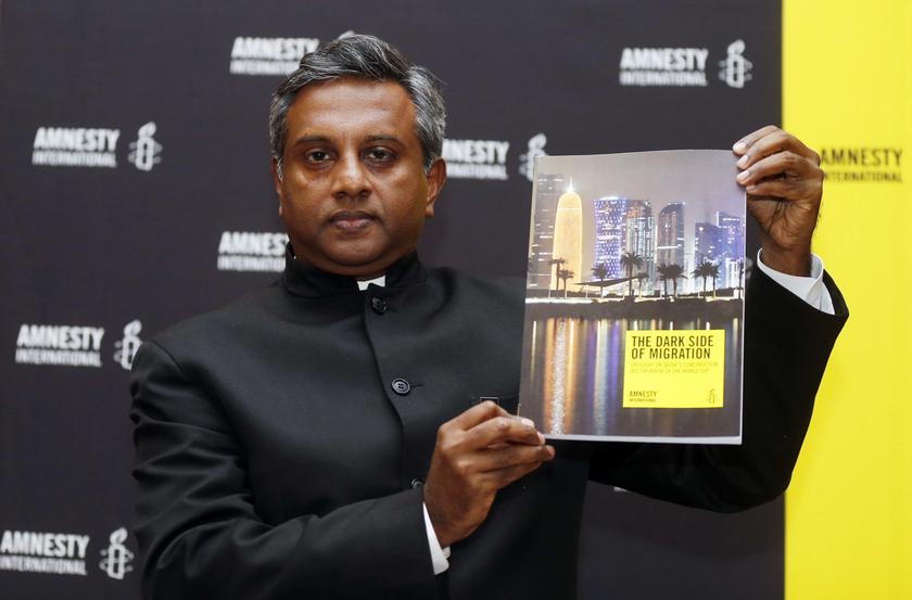 Amnesty International Secretary General Salil Shetty holds up a report titled 'The Dark Side of Migration: Spotlight on Qatar's construction sector ahead of the World Cup', during a news conference in Doha November 17, 2013. u00e2u20acu201d Reuters pic