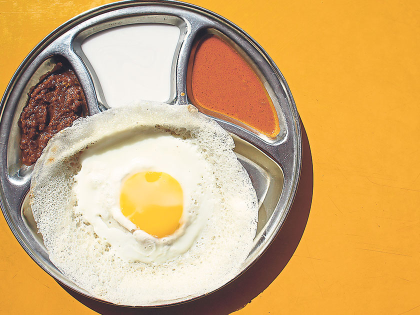 The appam telur with a runny egg yolk is served with coconut chutney, coconut milk or curry