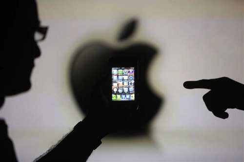 Men are silhouetted against a video screen with an Apple logo as they pose with an Apple iPhone 4 smartphone in this photo illustration taken in the central Bosnian town of Zenica, May 17, 2013. u00e2u20acu201d Reuters pic
