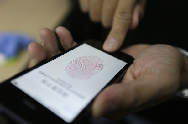 A journalist tests the the new iPhone 5S Touch ID fingerprint recognition feature at Apple Incu00e2u20acu2122s announcement event in Beijing, September 11, 2013. u00e2u20acu201d Reuters pic