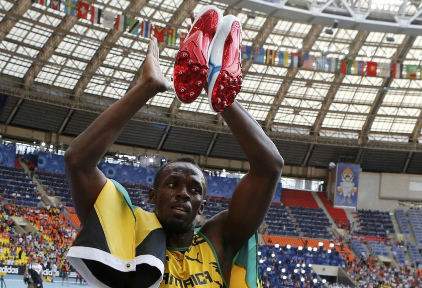 Usain Bolt of Jamaica holds aloft his track shoes as he celebrates winning the men's 4x100 metres relay final during the IAAF World Athletics Championships at the Luzhniki stadium in Moscow August 18, 2013