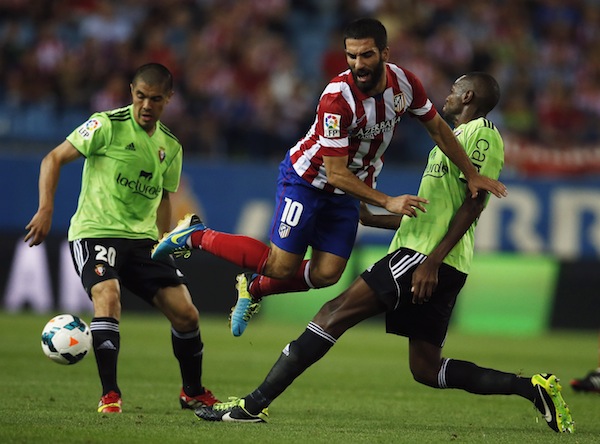 Atletico Madrid’s Arda Turan jumps between Osauna’s Raoul Loe (right) and Francisco Silva during their Spanish first division match in Madrid September 24, 2013. — Reuters pic