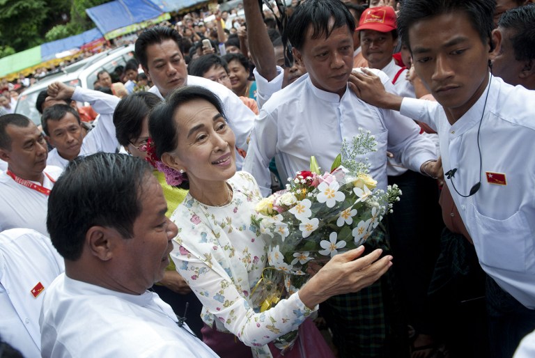  Myanmar opposition leader Aung San Suu Kyi (C) arrives at the National League for Democracy (NLD) headquarters to celebrate her 68th birthday, in Yangon on June 19, 2013. 
