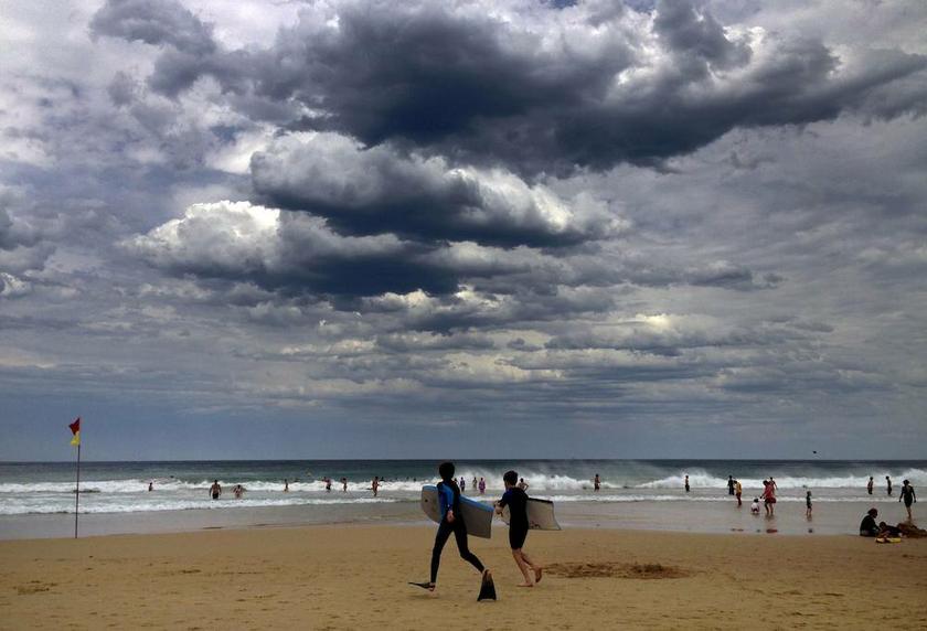 Two boys run into the surf as clouds gather above Manly Beach on a hot day in Sydney November 3, 2013. u00e2u20acu201d Reuters pic
