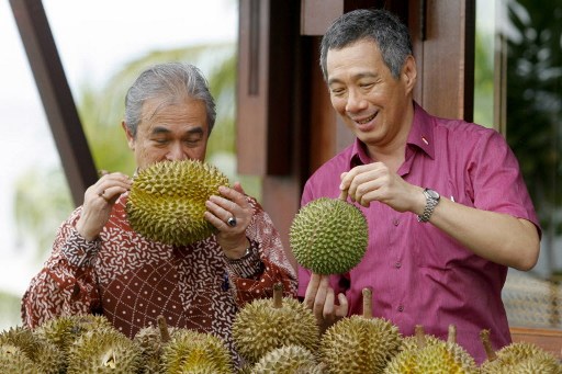Former PM Tun Abdullah Ahmad Badawi takes a sniff of a durian while his Singaporean counterpart Lee Hsien Loong inspects another specimen during a durian feast in Langkawi on May 15, 2007. u00e2u20acu201d AFP file pic