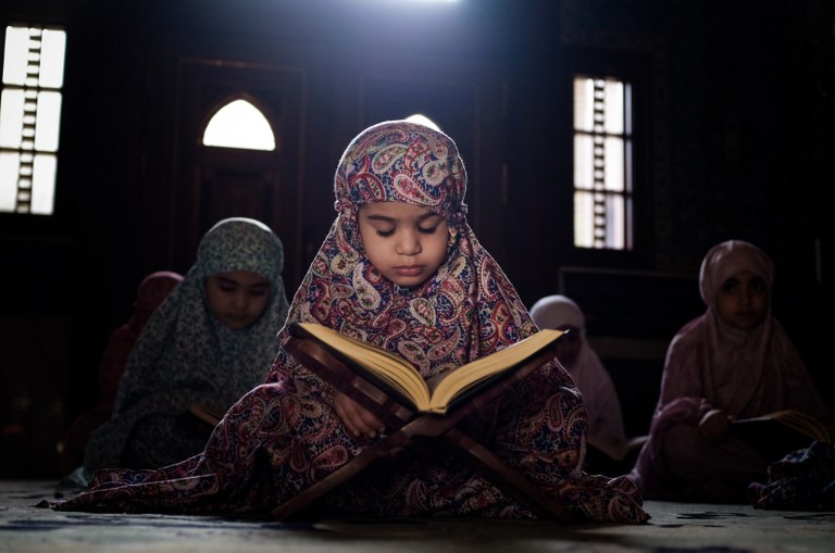 Young Bahraini Shiite Muslim girls read the Quran during the holy fasting month of Ramadan at a mosque in the village of Sanabis, west of Manama, on July 27, 2013. u00e2u20acu201d AFP pic