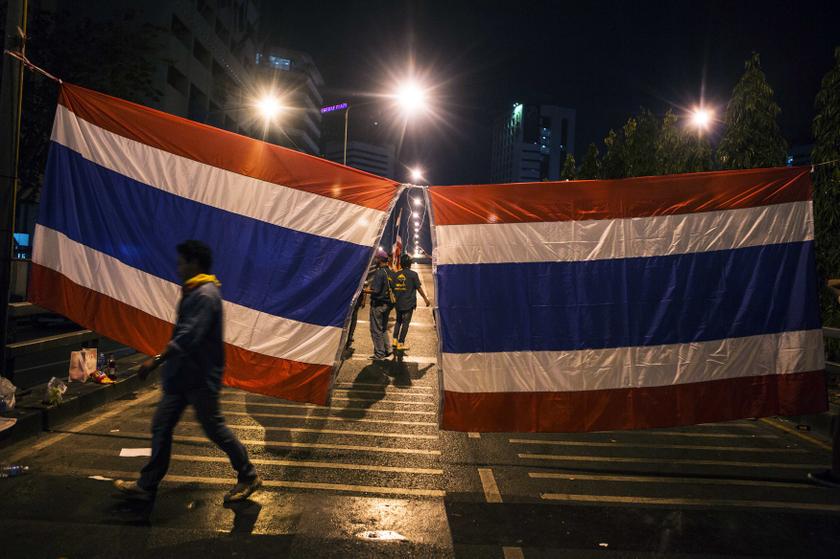 An anti-government protester walks past Thai national flags that were hung to block an entrance to a major bridge in central Bangkok, January 14, 2014. u00e2u20acu201d Reuters pic