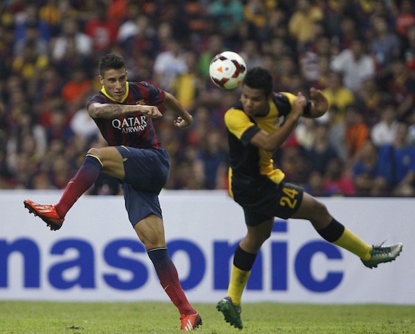 Barcelonau00e2u20acu2122s Cristian Tello (left) fights for the ball with Malaysia XIu00e2u20acu2122s Nik Mohd Shahrul Azim during their international friendly in Kuala Lumpur August 10, 2013. u00e2u20acu201d Reuters pic