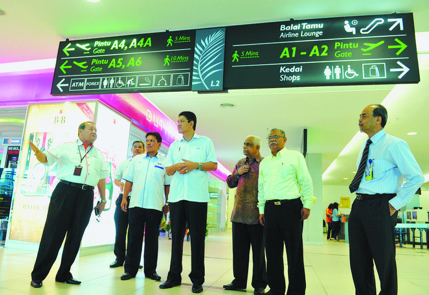 Malaysian Airports Holding Berhad senior general manager Datuk Azmi Murad explains some of the features at Penang International Airport to Zainal (centre). 