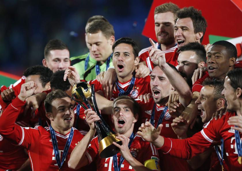 Germany's Bayern Munich Philipp Lahm (bottom centre) holds the trophy as he celebrates with his teammates after winning their 2013 FIFA Club World Cup final match against Morocco's Raja Casablanca at Marrakech stadium December 21, 2013.