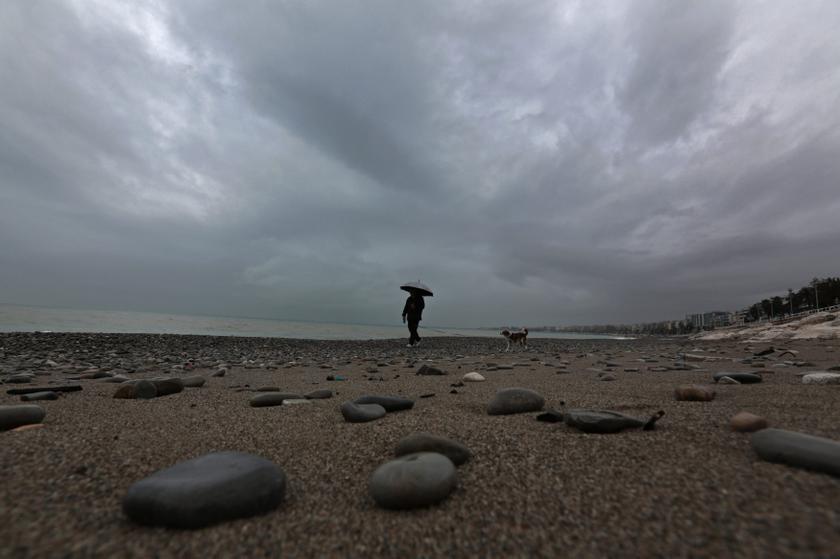 A man walks with his dog along a beach in Nice as heavy rain hits the French Riviera January 18, 2014. u00e2u20acu201d Reuters pic