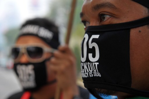Opposition supporters wear masks during a rally in Kuala Lumpur on June 22, 2013 to protest against the results of the countryu00e2u20acu2122s 13th general election of May 5. u00e2u20acu201d AFP pic