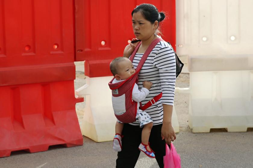 A mother carries her baby in a soft-structured carrier instead of pushing it in a stroller - a practice known as babywearing to promote mother-child proximity - as she walks about in Jalan Bukit Bintang. u00e2u20acu201c Picture by Choo  Choy May