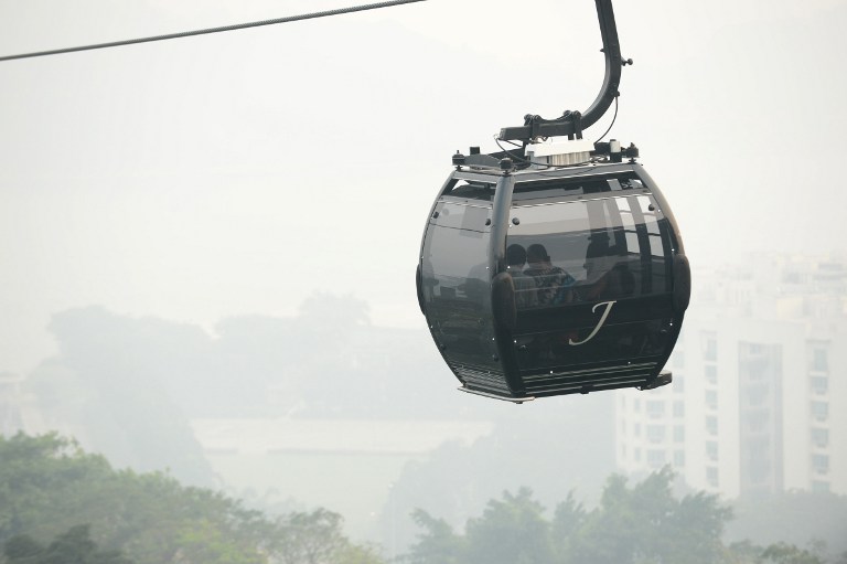 Tourists ride in a cable car as their surroundings are blanketed by haze in Singapore on June 19, 2013. u00e2u20acu201d AFP pic