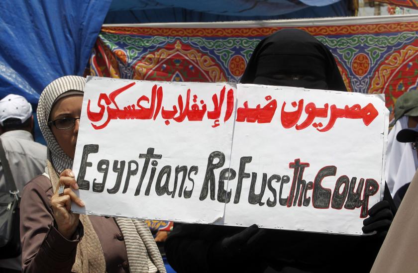 Supporters of ousted Egyptian President Mohamed Mursi hold a sign as they attend weekly Friday prayers at Rabaa Adawiya square, where they are camping, in Cairo July 12, 2013. u00e2u20acu201c Reuters pic