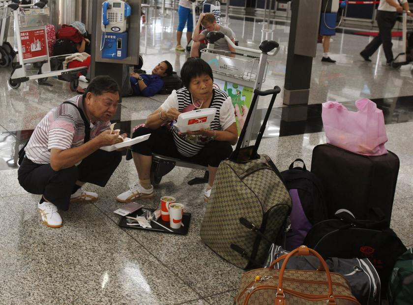 Mainland Chinese passengers eat lunch while waiting at Hong Kong Airport, as flights are cancelled in anticipation of typhoon Usagi, Sept 22, 2013. u00e2u20acu201d Reuters pic