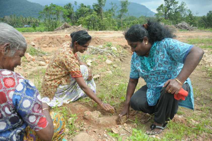 Local residents G. Sugunavelli (right) and Teresa Morri (left) digging out the base of candi number 11 after the structure was demolished in Lembah Bujang, Kedah December 2, 2013.