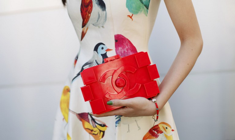A woman clutches her Chanel handbag as shows off her style outside the Lincoln Centre during the Mercedes-Benz Fashion Week Spring 2014 collections on September 7, 2013 in New York. — AFP pic