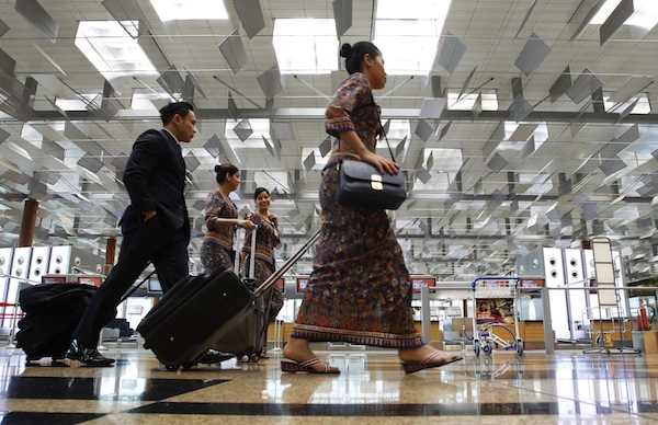 Singapore Airlines cabin crew walk past check-in counters at Terminal 3 of Singaporeu00e2u20acu2122s Changi Airport August 20, 2013. u00e2u20acu201d Reuters pic