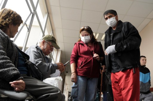 Patients wearing surgical masks wait to be assited at a hospital in Iquique, Chile on July 4, 2013. u00e2u20acu201d AFP pic