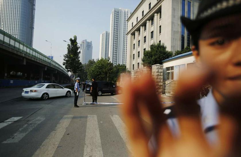 A policeman (right) tries to stop a journalist from photographing as vehicles enter a gate of the Jinan Intermediate Peopleu00e2u20acu2122s Court in China, where the trial of disgraced Chinese politician Bo Xilai will be held, on August 22, 2013. u00e2u20acu201d Reuters pic