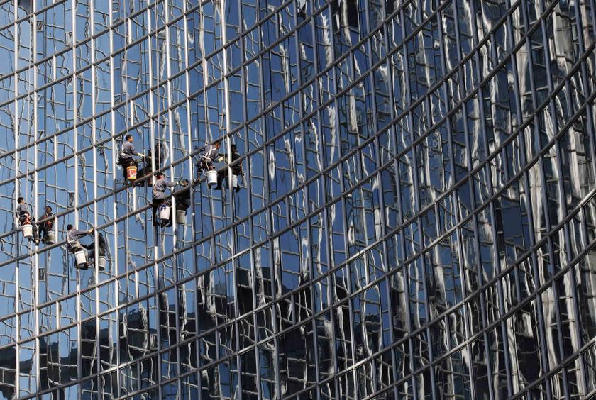 Workers clean a glass wall reflecting other skyscrapers at a hotel in Beijing, October 24, 2013. u00e2u20acu201d Reuters pic