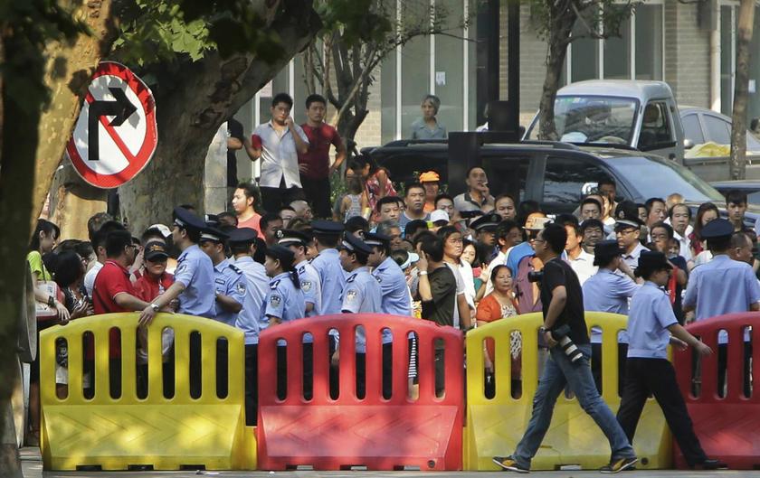 Police officers resume order behind a barricade after a rally staged by supporters of disgraced Chinese politician Bo Xilai, near the Jinan Intermediate People's Court, where his trial will be held in Jinan, Shandong province, August 22, 2013