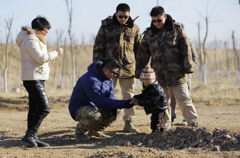 Bodyguards Han and Wang, who were hired from Tianjiao Special Guard/Security Consultant, watch their employer Zhang and his wife play with their three-year-old son as they guard the family on the outskirts of Beijing December 14, 2013. u00e2u20acu2022 Reuters pic