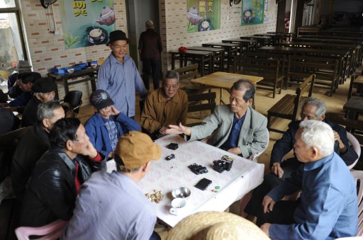 A group of elderly men play dominoes at a tea house in Chengmai city. — AFP pic
