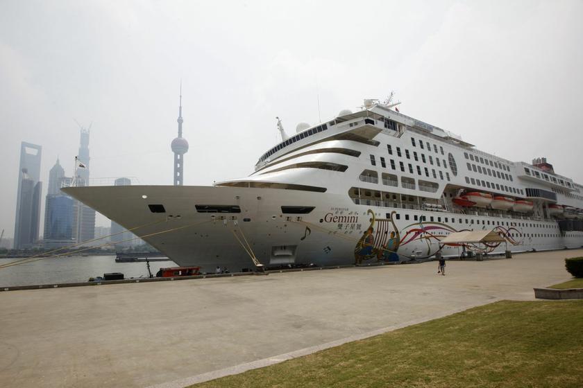 Hub of China's cruise industry: A man walks in front of a cruise ship docked in Shanghai Port International Cruise Terminal, opposite the Pudong financial area, in Shanghai August 11, 2013