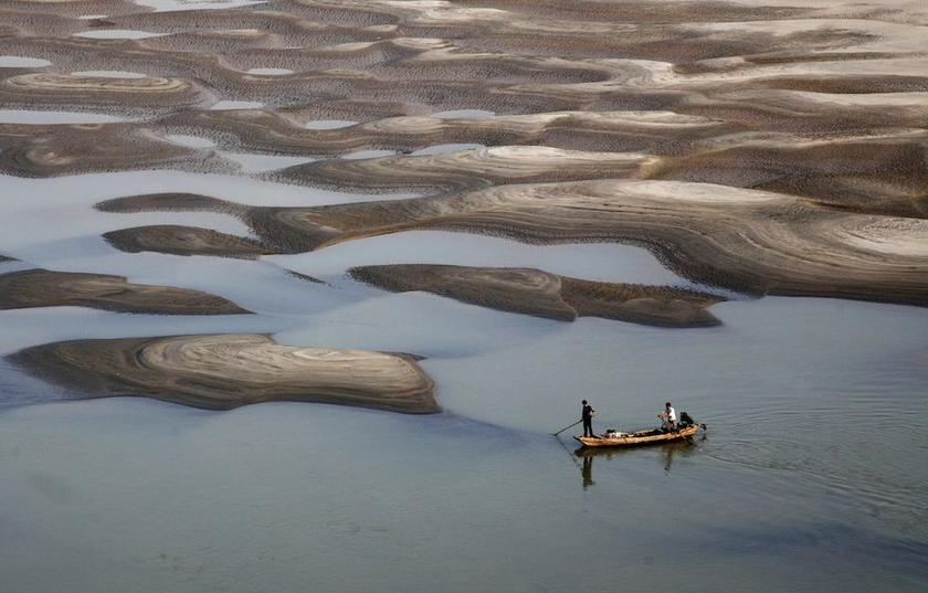 Two men row a boat past a partially dried-up riverbed on a section of the Yangtze River in Jiujiang, Jiangxi province October 27, 2013.u00e2u20acu201d Reuters pic