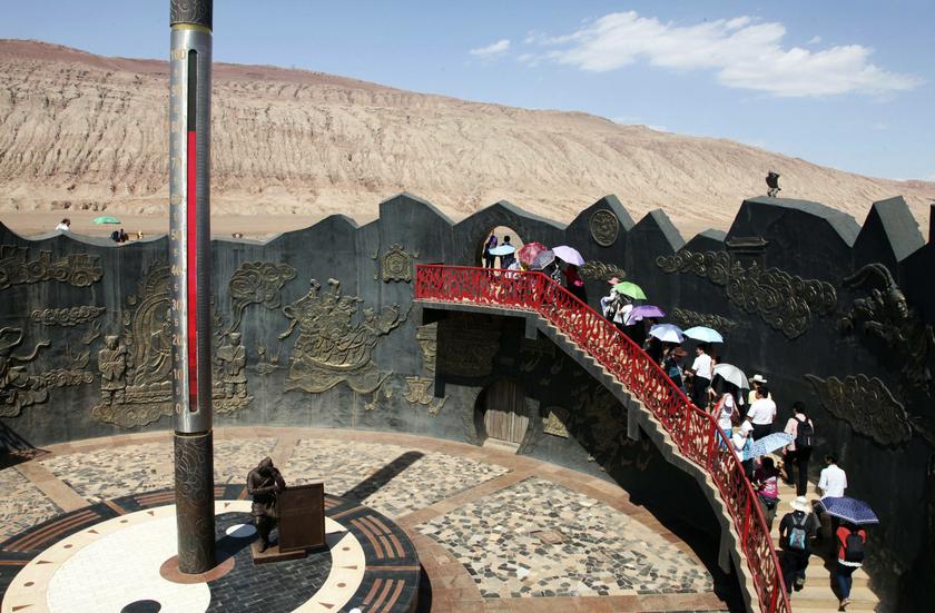 Chinese tourists walk past a huge thermometer near the Flaming Mountain (back) in Turpan, Xinjiang Uighur Autonomous Region, July 30, 2013. u00e2u20acu201c Reuters pic