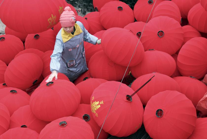 A worker walks among newly-made red lanterns as she and other workers prepare for the sales boom ahead of the Spring Festival at a family workshop in Wenxian county, Henan province January 7, 2014. u00e2u20acu201d Reuters pic