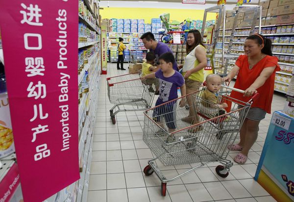 A family looks at imported milk powder products at a supermarket in Beijing in this July 3, 2013 file photo. u00e2u20acu201d Reuters pic