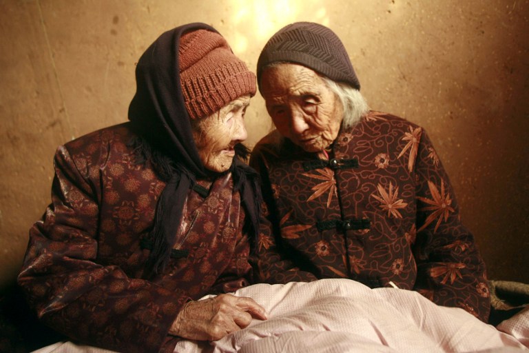 Chinese 104-year-old twins, Cao Daqiao (senior, right) and Cao Xiaoqiao talk at home in Weifang, east Chinau00e2u20acu2122s Shandong province on November 29, 2009. u00e2u20acu201d AFP pic