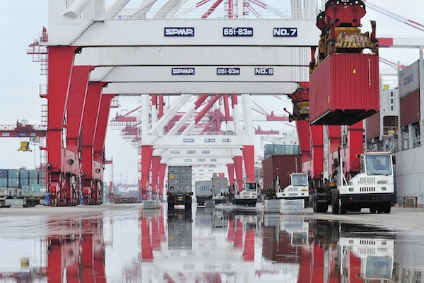 Trucks are loaded with shipping containers at a port in Yingkou, Liaoning province August 9, 2013. u00e2u20acu201d Reuters pic