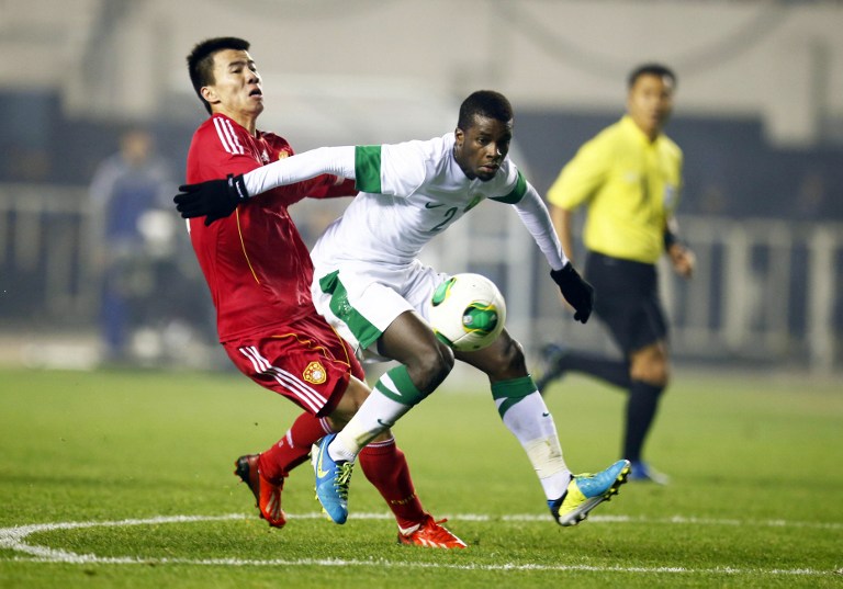 Sun Ke (L) of China tussles for the ball against Mansour al Harbi of Saudi Arabia during their 2015 Asian Cup group C qualifying football match in Xian, China's Shaanxi province on November 19, 2013. 
