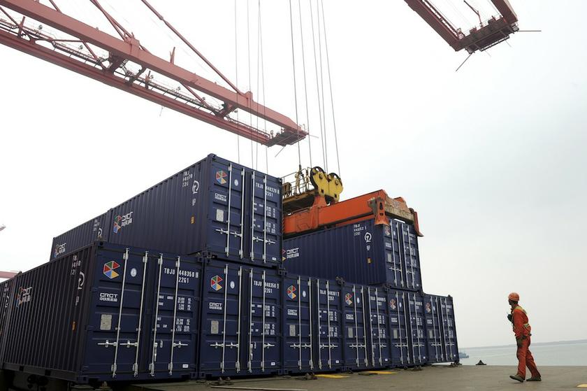 A worker stands near a crane unloading shipping containers from a cargo ship at a port in Lianyungang, Jiangsu province November 8, 2013. u00e2u20acu201d Reuters pic