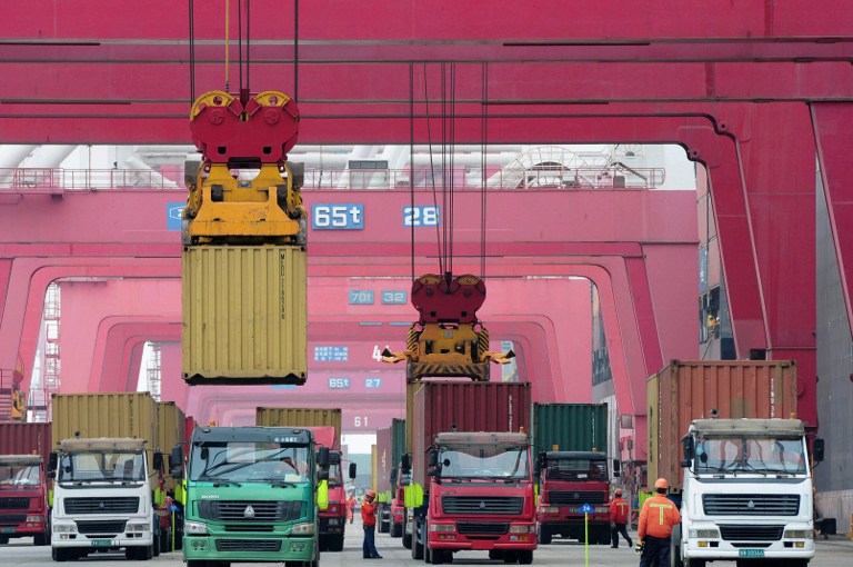 Shipping containers are transported in a port in Qingdao, east China's Shandong province on May 8, 2013. u00e2u20acu201d AFP pic
