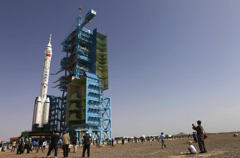 Visitors take pictures as China's Shenzhou 10 spacecraft and its carrier Long March 2-F rocket are being transferred to its launching site at Jiuquan Satellite Launch Center in Jiuquan, Gansu province June 3, 2013. 
