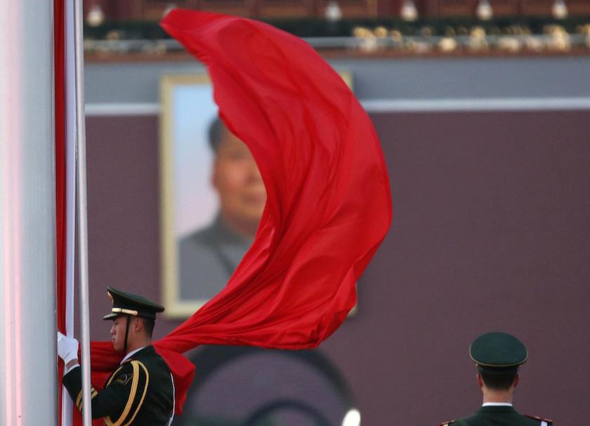 A paramilitary policeman holds the Chinese national flag at a flag lowering ceremony on Tiananmen square next to the Great Hall of the People, in Beijing, November 11, 2013. u00e2u20acu201d Reuters pic