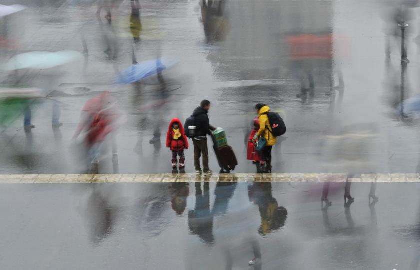 A long exposure photo shows a family standing under the rain outside a railway station in Hefei, Anhui province, February 6, 2014. u00e2u20acu201du00c2u00a0Reuters pic