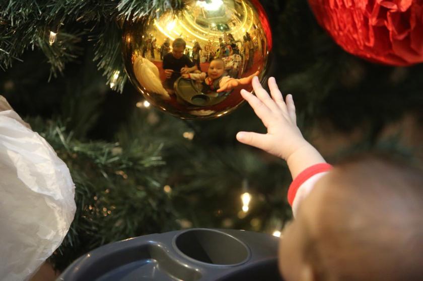 A baby trying to grab a hold of a Christmas decorative bauble hanging from a Christmas tree at Mid Valley Megalmall in Kuala Lumpur, December 24, 2013. u00e2u20acu201d Picture by Choo Choy May