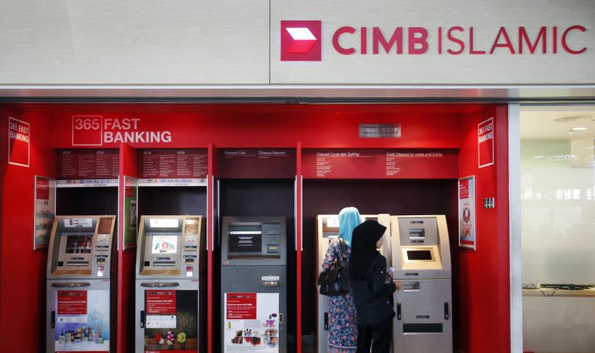 People withdraw cash from an automatic teller machine at a CIMB Islamic branch in Sepang outside Kuala Lumpur August 26, 2013. u00e2u20acu201c Reuters pic