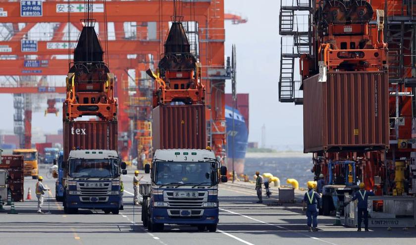 Workers load containers from trucks onto a cargo ship at a port in Tokyo on August 19, 2013. u00e2u20acu201d Reuters pic