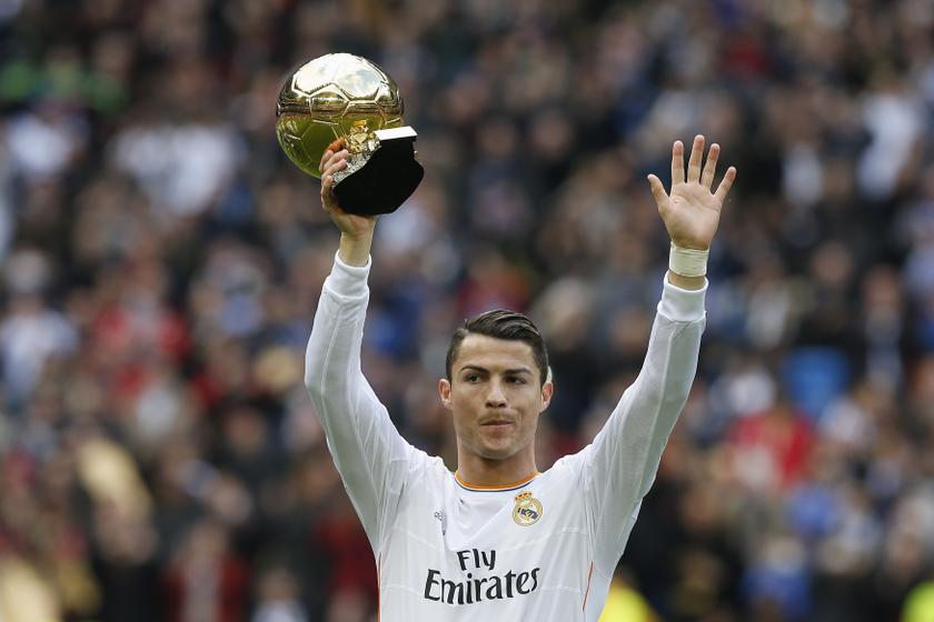 Real Madrid's Cristiano Ronaldo holds his Ballon d'Or (Golden Ball) trophy to the crowd after winning the FIFA World Player of the Year 2013 award, before their match against Granada at the Santiago Bernabeu stadium in Madrid January 25, 2014. u00e2u20acu201d Reuters