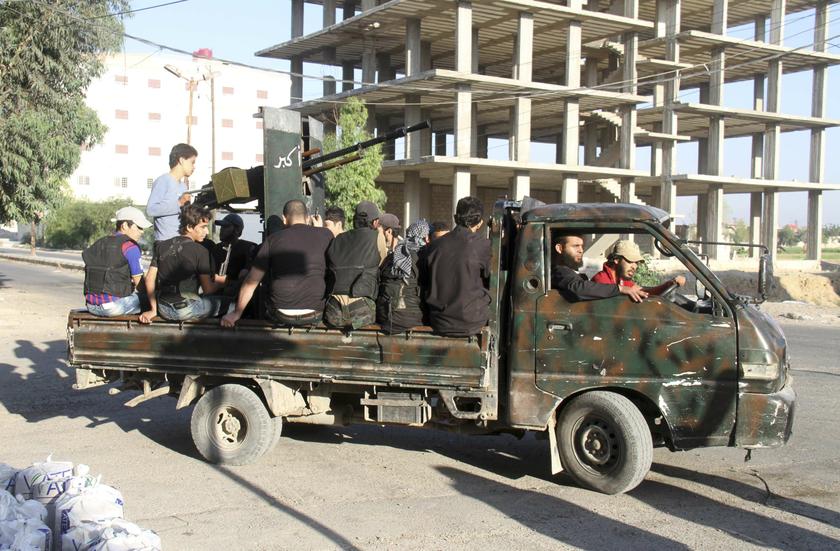 Free Syrian Army fighters sit on a pick-up truck mounted with an anti-aircraft weapon near the frontline where clashes with forces loyal to Syria's President Bashar al-Assad are taking place in Beit Hajira near Damascus, July 7, 2013.