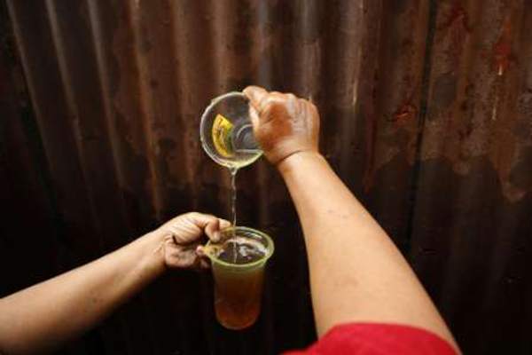 A woman collects diesel fuel from a leakage in Indonesiau00e2u20acu2122s state oil and gas firm oil pipeline in Jakarta on May 22, 2008. u00e2u20acu201d Reuters pic
