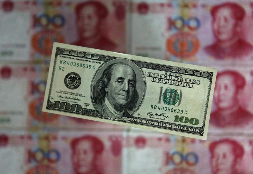 A photo illustration shows a US$100 banknote placed above Chinese 100 yuan banknotes in Beijing May 10, 2013. u00e2u20acu201d Reuters pic